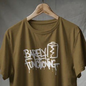 Camiseta "Apenas Funcionando" / Humor sobre el agotamiento. Estampado digital (unisex).