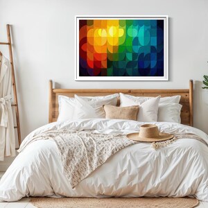 May include: A bedroom scene featuring a wooden bed frame with white bedding, a beige throw, and a straw hat. A colorful abstract art piece hangs above the bed. A wooden ladder with a robe and a side table with a plant complete the decor.