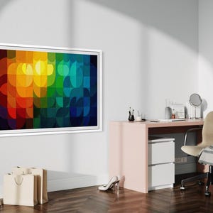 May include: A framed abstract art piece with a vibrant, colorful design dominates the scene. The artwork features a pattern of overlapping shapes in shades of red, orange, yellow, green, blue, and purple. The room also includes a desk, chair, and shopping bags.