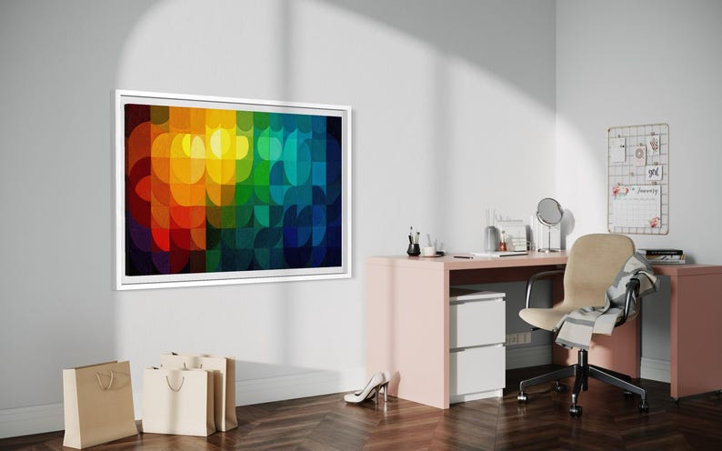 May include: A framed abstract art piece with a vibrant, colorful design dominates the scene. The artwork features a pattern of overlapping shapes in shades of red, orange, yellow, green, blue, and purple. The room also includes a desk, chair, and shopping bags.