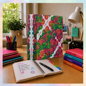 May include: A three-ring binder with a vibrant floral pattern in shades of pink, green, and yellow. The spine and cover feature the text 2026-2027, Austin High, Senior, and Jennifer Friend. An open notebook with a goals list and a black pen.
