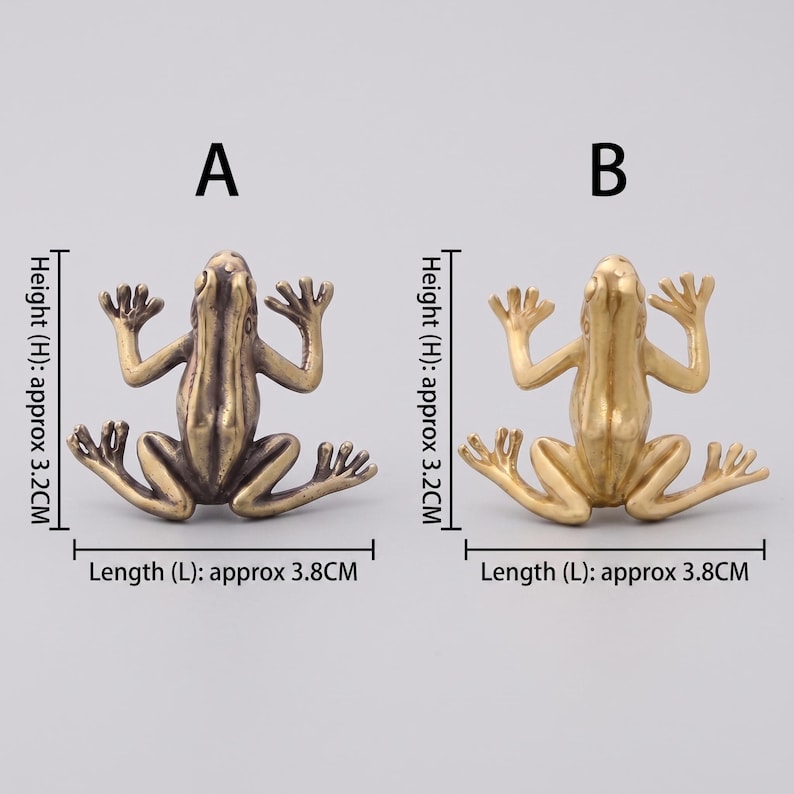 May include: Two metal frog figurines labeled A and B. Frog A has a dark bronze finish, while frog B has a bright gold finish. Each frog measures approximately 3.2 cm in height and 3.8 cm in length. Both frogs are depicted in a flat, splayed position.