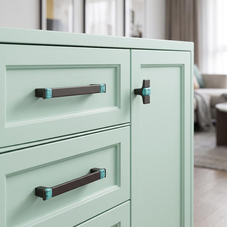 Peut inclure: Un meuble vert menthe clair dot&eacute; de deux poign&eacute;es de tiroir rectangulaires horizontales et d'un bouton de porte en forme de T. La quincaillerie est brun fonc&eacute; avec des accents en pierre turquoise vive aux extr&eacute;mit&eacute;s et au centre.