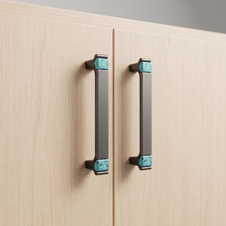 Peut inclure: Deux poign&eacute;es de placard verticales en m&eacute;tal gris fonc&eacute; avec des incrustations rectangulaires en pierre turquoise aux extr&eacute;mit&eacute;s sup&eacute;rieure et inf&eacute;rieure. Les poign&eacute;es sont fix&eacute;es sur des portes en bois clair &agrave; grain vertical.