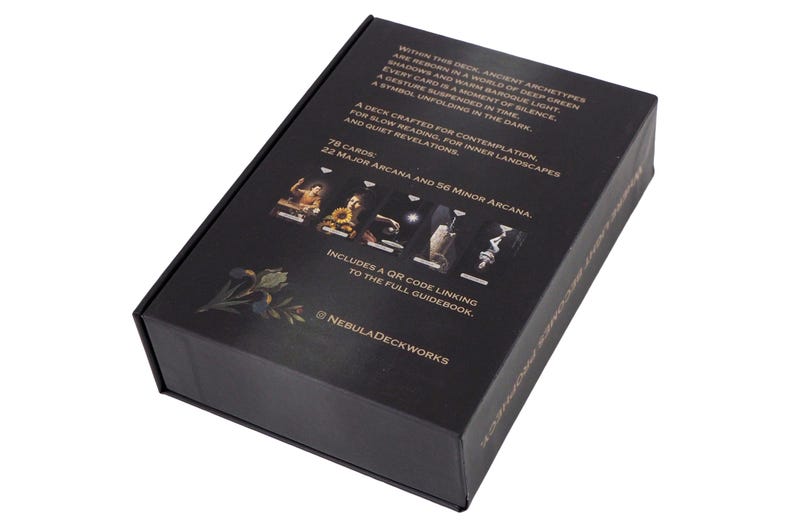 May include: A black rectangular box with gold text and images. The box contains a deck of cards with 78 cards, including 22 Major Arcana and 56 Minor Arcana. The box includes a QR code linking to the full guidebook. The brand name is Nebula Deckworks.