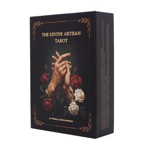 May include: A black tarot card box with the title "THE DIVINE ARTISAN TAROT" in gold lettering. The box features an illustration of clasped hands surrounded by red and white roses. The box is rectangular and has gold decorative accents.