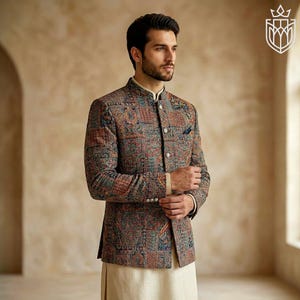 May include: A patterned jacket with a mandarin collar, featuring a mix of colors including blue, red, and brown. The jacket has a pocket square and buttoned cuffs. The person is wearing a cream-colored shirt and pants.