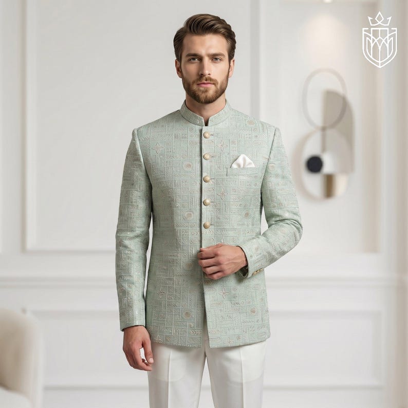 K&ouml;nnte beinhalten: Hellgr&uuml;ne Jacke mit Stehkragen und goldenen Kn&ouml;pfen. Die Jacke hat ein dezentes geometrisches Muster und wird mit einer wei&szlig;en Hose kombiniert. Ein wei&szlig;es Einstecktuch ist sichtbar. Das Outfit ist formell und elegant.