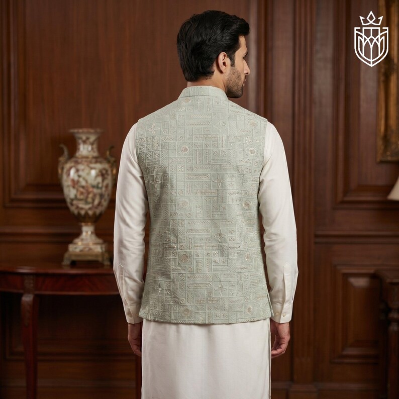 May include: A light green vest with a geometric pattern, worn over a white long-sleeve shirt and white pants. The vest has a mandarin collar and a detailed design. The outfit is suitable for formal occasions.