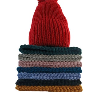 a stack of knitted hats sitting on top of a table