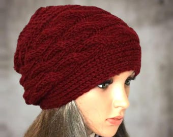 May include: A burgundy knitted beanie with a cable knit pattern. The beanie is made of soft, warm yarn and is perfect for keeping your head warm in the winter.