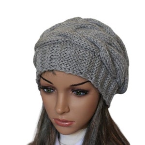 a mannequin head wearing a gray knitted hat