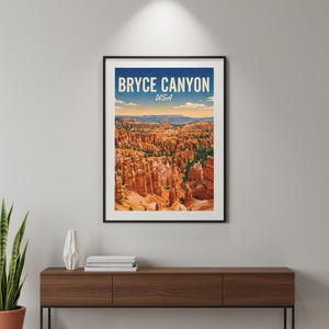 May include: A framed art print featuring Bryce Canyon National Park in Utah, USA. The print displays a colorful landscape of the canyon's unique rock formations under a blue sky. The print is displayed on a dark wood console table.