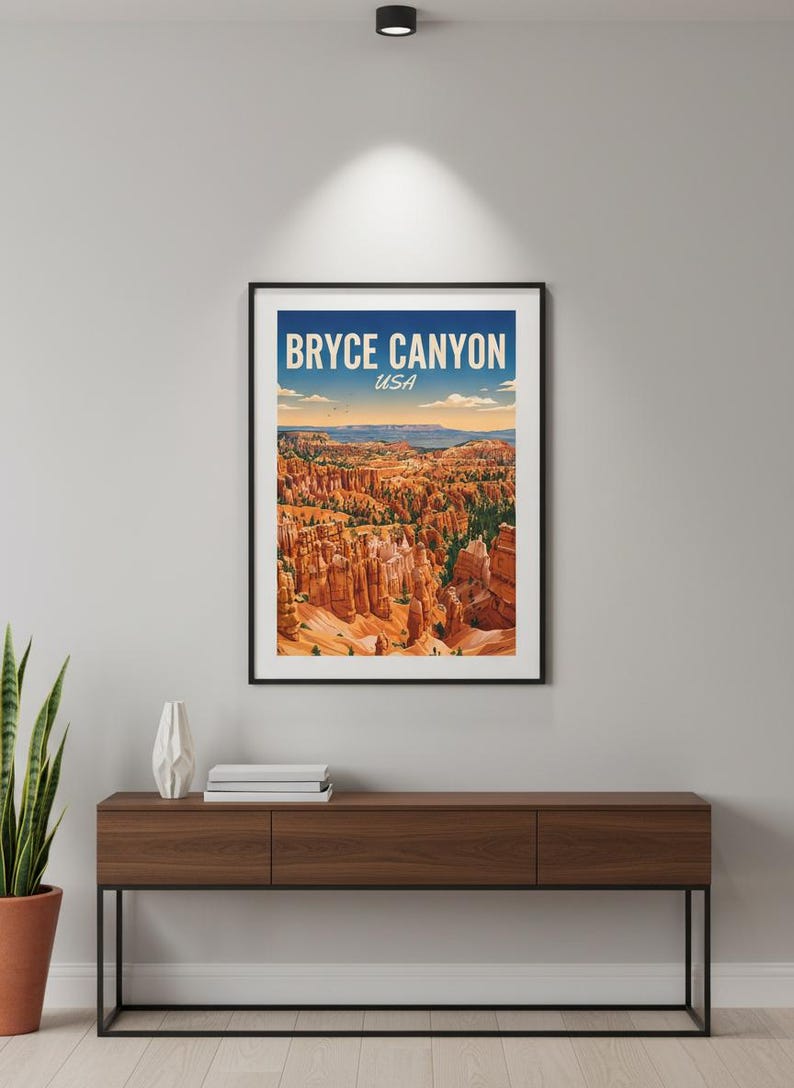 May include: A framed art print featuring Bryce Canyon National Park in Utah, USA. The print displays a colorful landscape of the canyon's unique rock formations under a blue sky. The print is displayed on a dark wood console table.