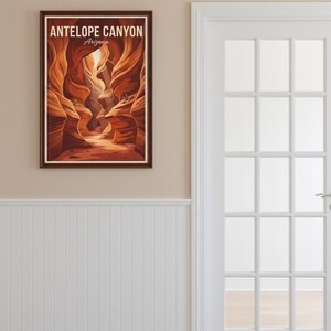 May include: A framed print of Antelope Canyon in Arizona. The artwork depicts the canyon's sandstone walls in shades of orange and brown, with the text "ANTELOPE CANYON Arizona" at the top. The print hangs on a beige wall next to a white door.