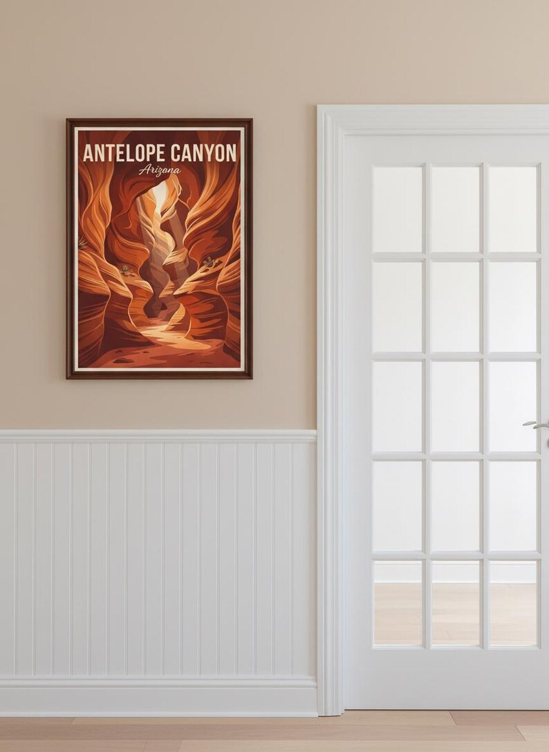 May include: A framed print of Antelope Canyon in Arizona. The artwork depicts the canyon's sandstone walls in shades of orange and brown, with the text "ANTELOPE CANYON Arizona" at the top. The print hangs on a beige wall next to a white door.