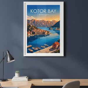 May include: Framed art print of Kotor Bay, Montenegro. The artwork depicts a coastal town with boats on the water, mountains in the background, and the text "Kotor Bay Montenegro" at the top. The color palette includes blues, oranges, and greens.