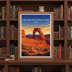 May include: Framed art print featuring a landscape of Arches National Park in Utah. The artwork depicts a large sandstone arch under a blue sky with the text "Arches National Park Utah". The print is displayed on a wooden bookshelf.