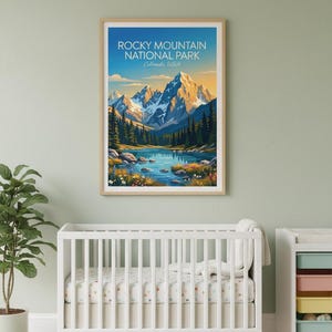 May include: A framed print of Rocky Mountain National Park, Colorado, USA. The artwork shows a mountain range with snow-covered peaks, a lake, and evergreen trees. The sky transitions from blue to yellow.