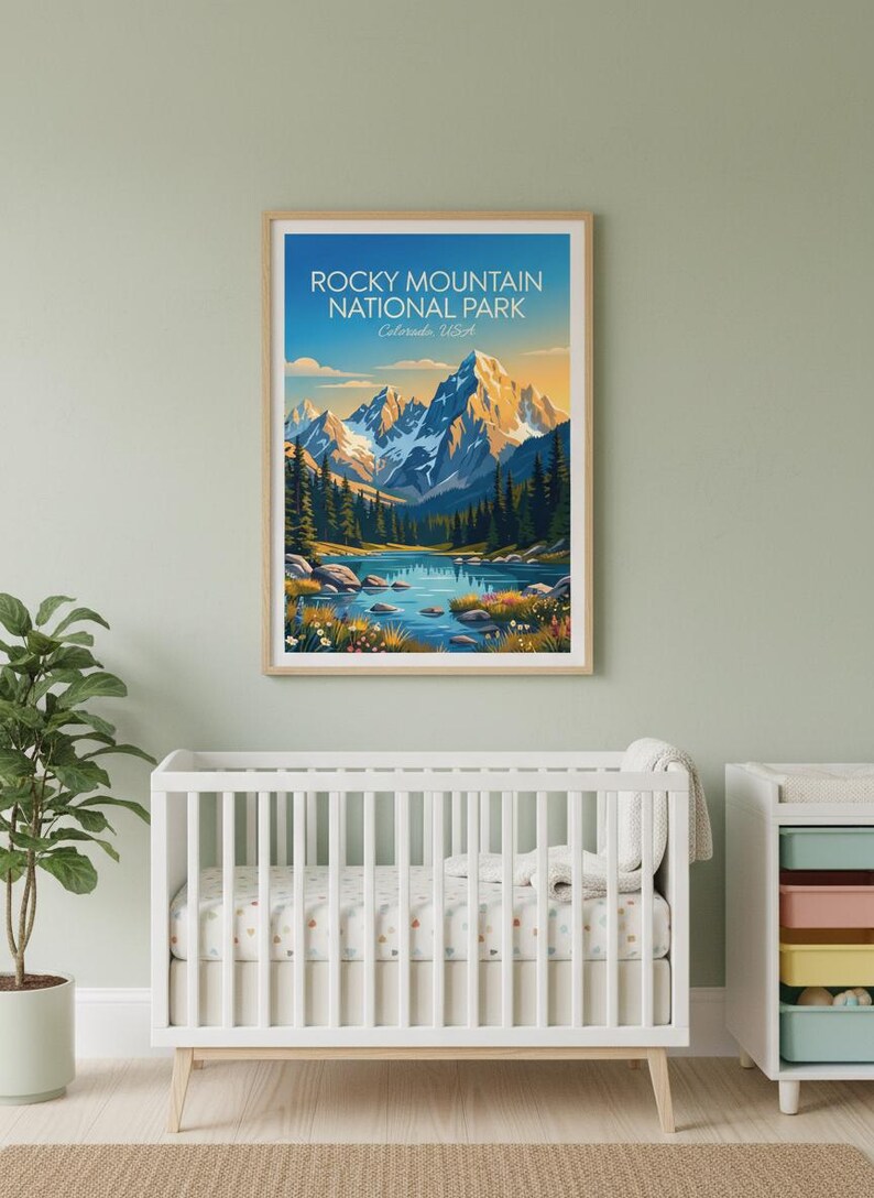 May include: A framed print of Rocky Mountain National Park, Colorado, USA. The artwork shows a mountain range with snow-covered peaks, a lake, and evergreen trees. The sky transitions from blue to yellow.