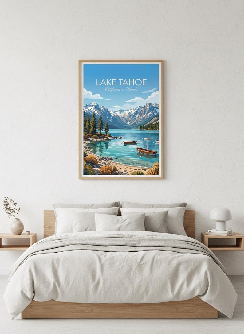 May include: A framed art print of Lake Tahoe, California, featuring a serene lake scene with boats, mountains, and trees under a blue sky. The print is displayed above a bed with neutral-colored bedding.