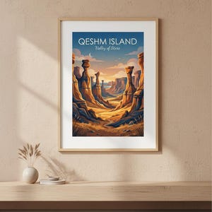 May include: Framed art print depicting a desert landscape with tall rock formations under a blue sky. The print reads "Qeshm Island Valley of Stars" in white text. The artwork is in a wooden frame, displayed on a light-coloured wall.
