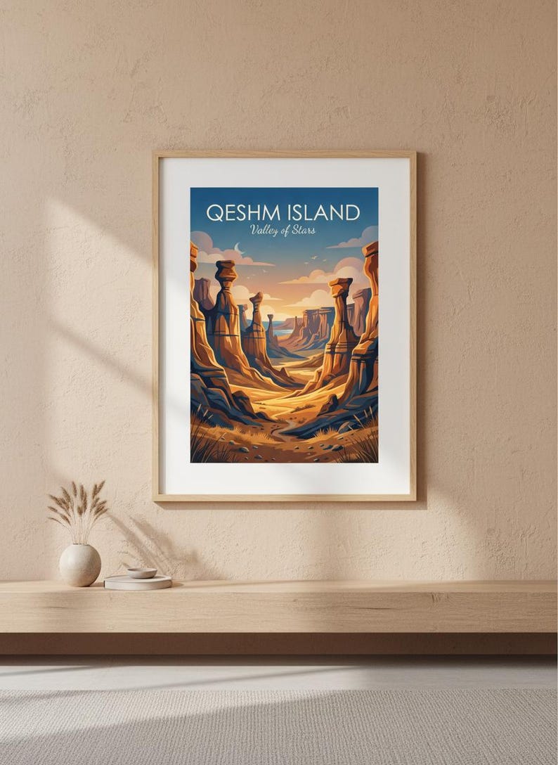May include: Framed art print depicting a desert landscape with tall rock formations under a blue sky. The print reads "Qeshm Island Valley of Stars" in white text. The artwork is in a wooden frame, displayed on a light-coloured wall.