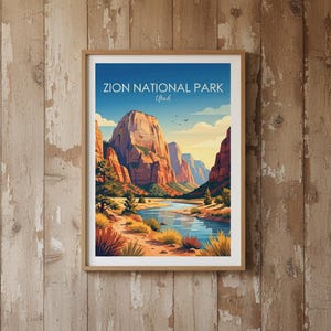 May include: A framed art print featuring a landscape illustration of Zion National Park, Utah. The image displays towering red rock cliffs, a winding blue river, and desert vegetation under a clear sky with the text Zion National Park Utah.