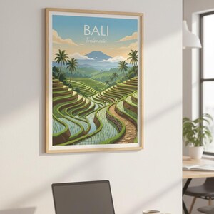 May include: A framed wall art print featuring a landscape illustration of Bali, Indonesia, with green terraced rice fields, palm trees, and a distant mountain under a blue sky. The text BALI Indonesia is printed in white at the top center.