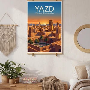 May include: A poster print showing a stylized illustration of Yazd, Iran, with the text "YAZD Historic Windcatchers" in white. The artwork depicts a cityscape with wind towers under a sunset sky, in shades of orange, blue, and brown.