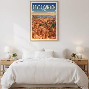 May include: A framed print of Bryce Canyon National Park in Utah, USA, hangs above a bed. The artwork features a landscape of orange rock formations under a blue sky. The print is in a light wood frame.