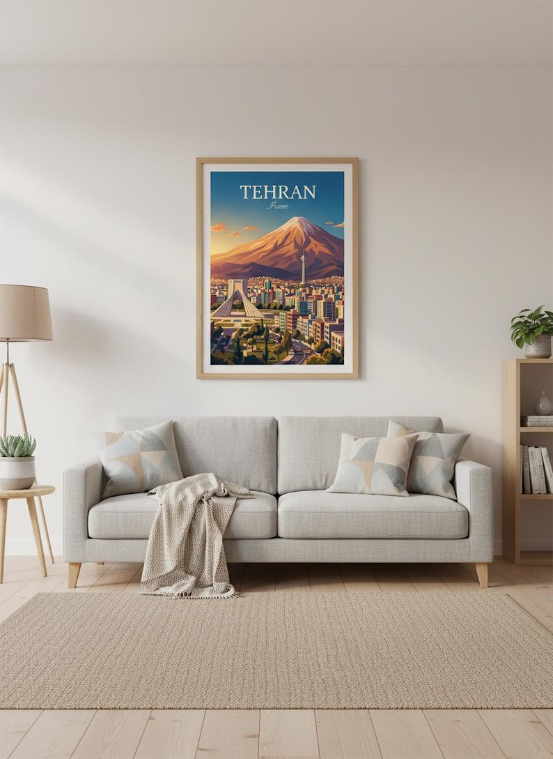 May include: A framed art print featuring a stylized illustration of Tehran, Iran. The artwork depicts a mountain, city buildings, and the text "TEHRAN" in a blue sky. The print is displayed above a gray sofa with decorative pillows.