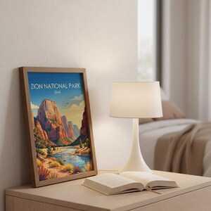 May include: A framed vertical art print featuring a colorful illustration of Zion National Park, Utah, with red rock cliffs, a winding river, and desert vegetation under a blue sky. The text Zion National Park Utah is printed at the top.
