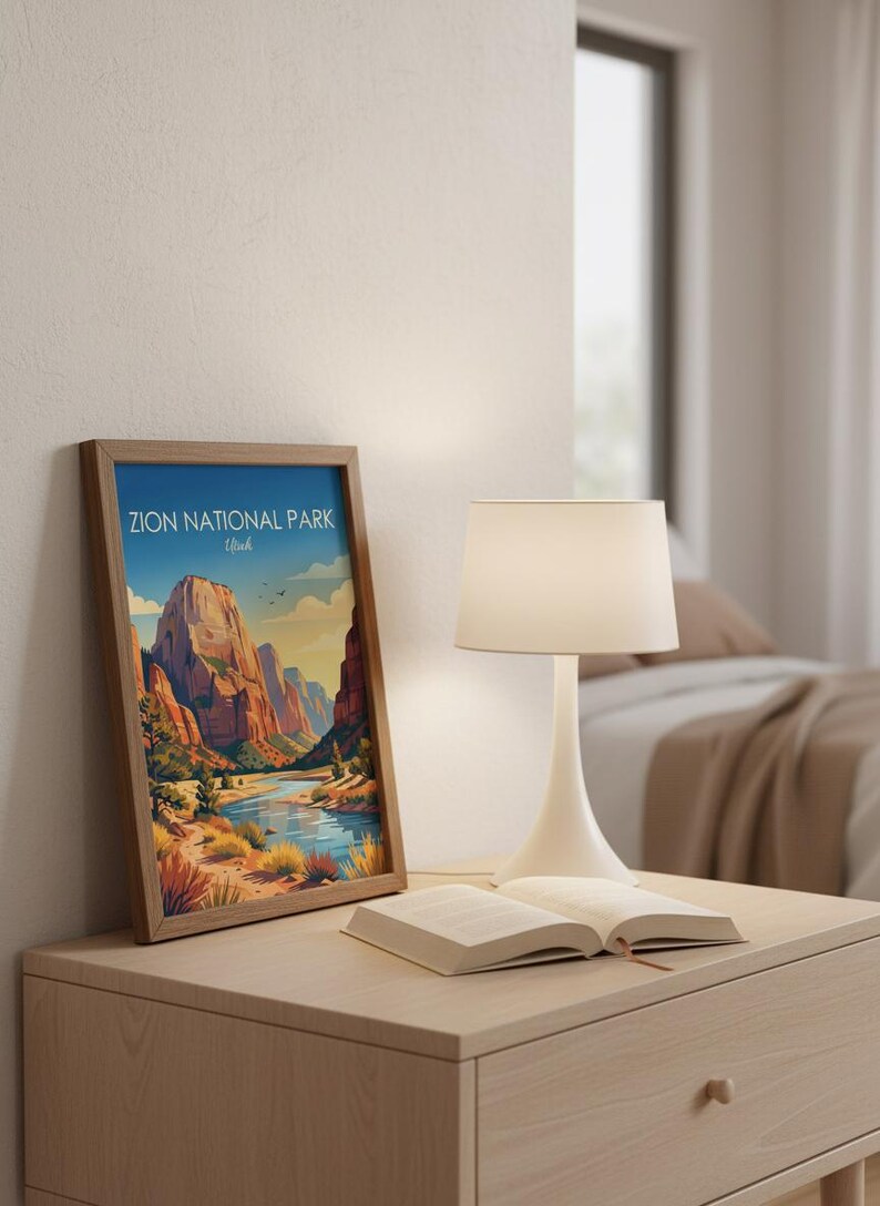 May include: A framed vertical art print featuring a colorful illustration of Zion National Park, Utah, with red rock cliffs, a winding river, and desert vegetation under a blue sky. The text Zion National Park Utah is printed at the top.