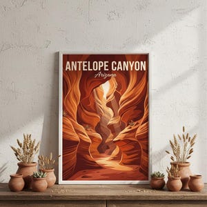 May include: A framed art print featuring Antelope Canyon in Arizona. The artwork depicts the canyon's sandstone walls in shades of orange and brown, with the text "ANTELOPE CANYON Arizona" at the top. The print is displayed on a wooden cabinet with terracotta pots.