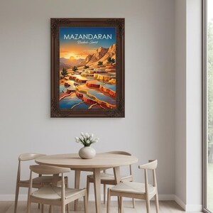 Peut inclure: Une affiche encadr&eacute;e repr&eacute;sentant un paysage de Mazandaran, avec le texte "MAZANDARAN Bodab-e Surt". L'&oelig;uvre d'art repr&eacute;sente des piscines en terrasses color&eacute;es et des montagnes sous un ciel de coucher de soleil. Le cadre est marron fonc&eacute;. L'affiche est au-dessus d'une table et de chaises en bois.