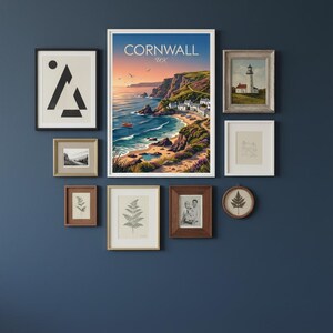 May include: A gallery wall arrangement featuring framed art prints. The collection includes a landscape print with the text "Cornwall UK", a lighthouse painting, botanical illustrations, and abstract art. The frames vary in size and style, creating a visually appealing display.