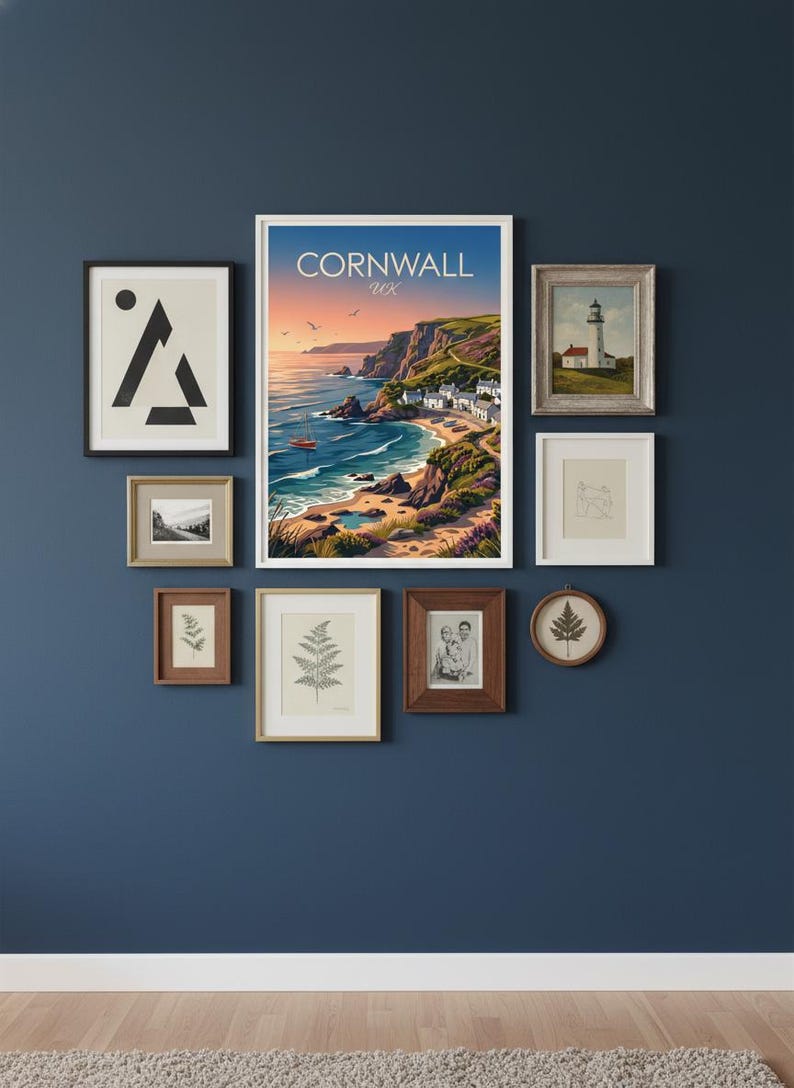 May include: A gallery wall arrangement featuring framed art prints. The collection includes a landscape print with the text "Cornwall UK", a lighthouse painting, botanical illustrations, and abstract art. The frames vary in size and style, creating a visually appealing display.