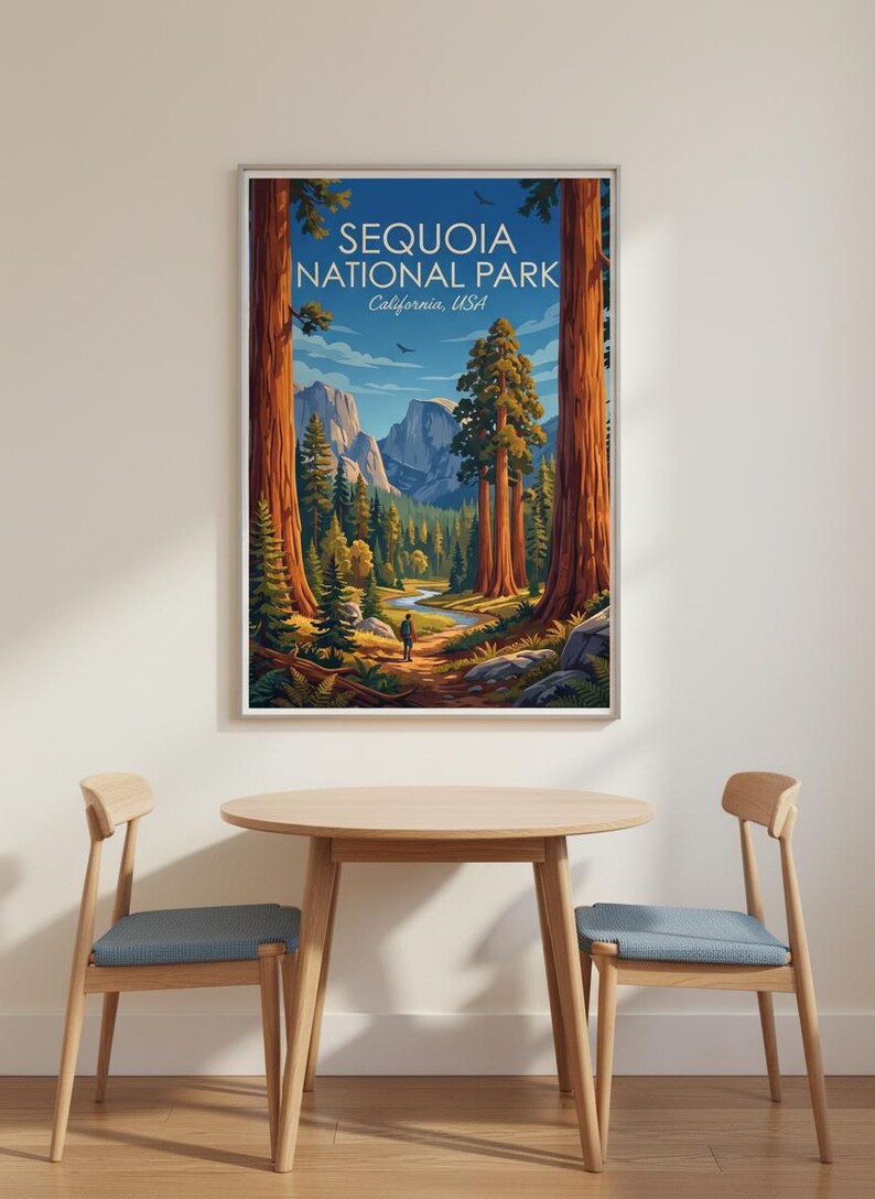 Op de afbeelding: Een ingelijste print van Sequoia National Park, Californi&euml;, VS. De illustratie toont een vallei met sequoia's, een rivier en bergen. Een persoon is te zien op een pad. De print wordt weergegeven boven een houten tafel en stoelen.