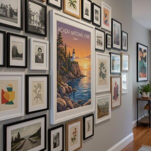 Puede incluir: Una pared de galer&iacute;a con impresiones art&iacute;sticas enmarcadas de varios tama&ntilde;os y estilos. La colecci&oacute;n incluye fotograf&iacute;as en blanco y negro, ilustraciones bot&aacute;nicas y una gran impresi&oacute;n del Parque Nacional Acadia en Maine, con un faro al atardecer.