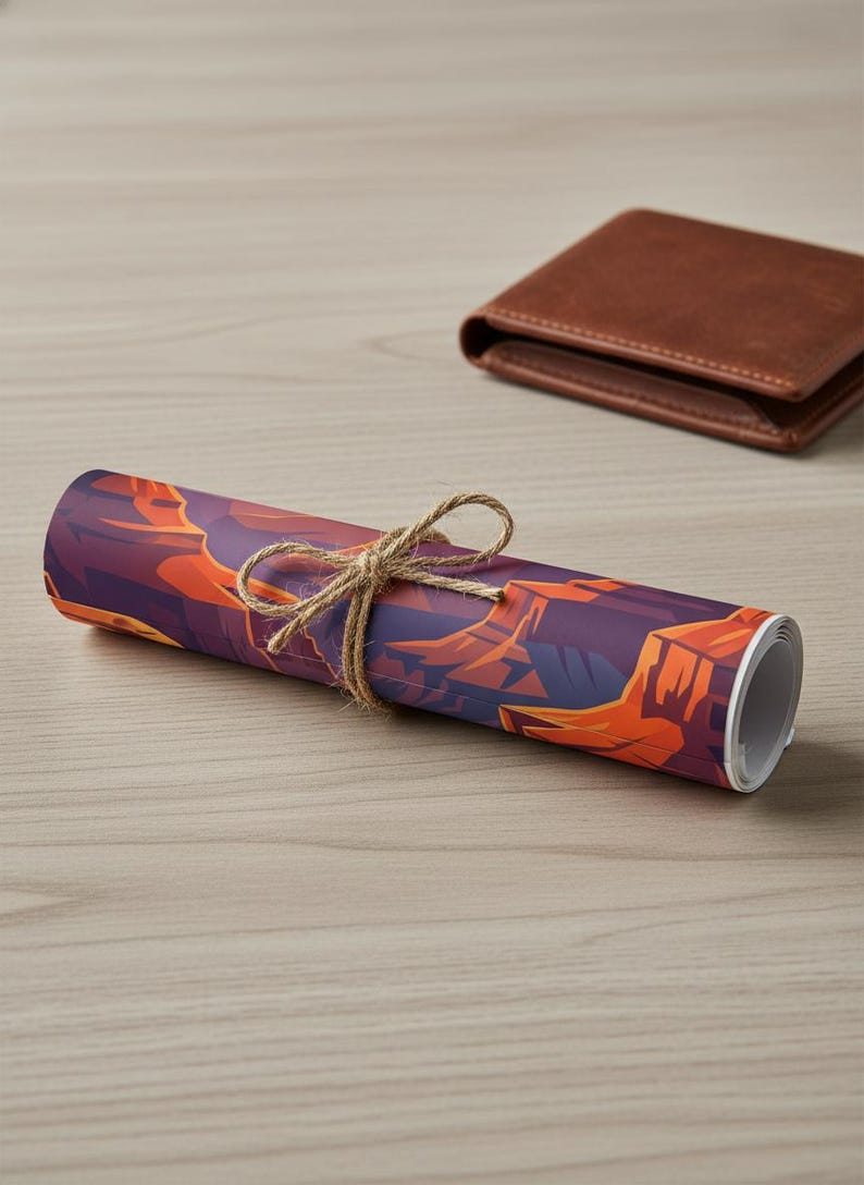 May include: Rolled art print featuring a canyon landscape in shades of purple and orange, tied with twine. A brown leather wallet rests in the background on a light wood surface. The print is a decorative item.