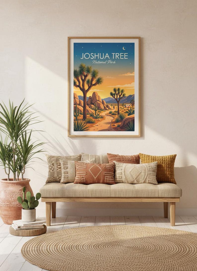 May include: A framed print of Joshua Tree National Park, featuring a desert landscape with Joshua trees, rocks, and a path. The print hangs above a bench with decorative pillows. A potted plant and cactus are also visible.