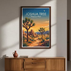 May include: A framed art print featuring a desert landscape with Joshua trees, cacti, and a path leading to the horizon. The artwork has a warm color palette of oranges, blues, and yellows, with the text "JOSHUA TREE National Park" at the top.
