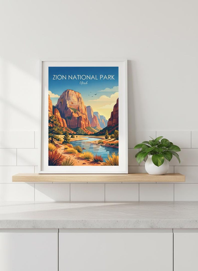 May include: A framed art print featuring a landscape illustration of Zion National Park, Utah, with towering red rock cliffs, a winding blue river, and desert vegetation under a clear sky. The text Zion National Park Utah is printed at the top.