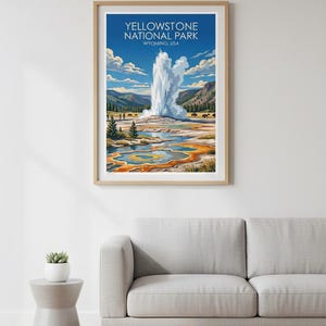 Pode incluir: Uma impress&atilde;o emoldurada do Parque Nacional de Yellowstone, Wyoming, EUA. A obra de arte retrata um g&ecirc;iser em erup&ccedil;&atilde;o com um pano de fundo de montanhas, &aacute;rvores e uma &aacute;rea termal colorida. O c&eacute;u &eacute; azul com nuvens fofas.