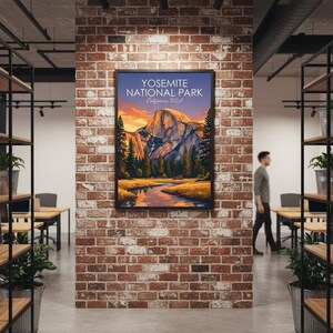May include: A framed poster featuring a scenic view of Yosemite National Park, California, USA. The artwork depicts a mountain landscape with a river, trees, and a sunset. The poster is displayed on a brick wall in an office setting.