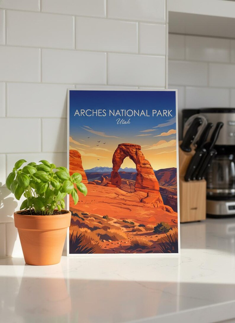 May include: A framed print of Arches National Park in Utah. The artwork depicts the iconic Delicate Arch in a vibrant landscape of red rock formations under a blue sky. Text at the top reads "Arches National Park Utah."