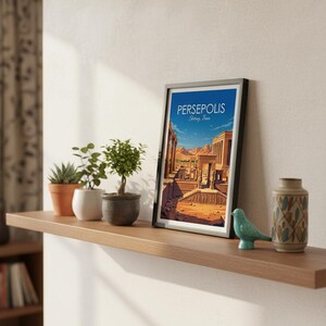 May include: A framed art print with the word "PERSEPOLIS" and "Shiraz, Iran" on the top. The print depicts an ancient city with columns and buildings. The print is on a wooden shelf with small potted plants, a teal bird figurine, and a decorative vase.