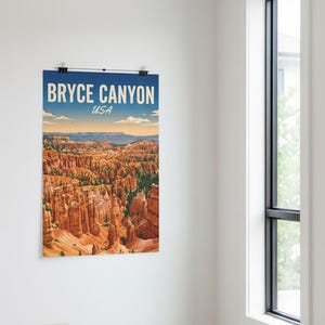 May include: Bryce Canyon USA poster print. The poster features a scenic view of the canyon with orange rock formations under a blue sky. The poster is held in place by two black clips.