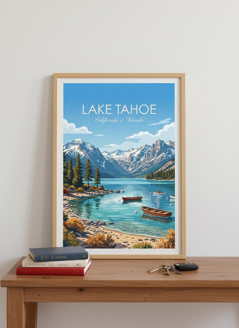May include: Framed art print of Lake Tahoe, California & Nevada. The image features a serene lake scene with boats, mountains, and a clear blue sky. The artwork is displayed on a wooden table with books and keys.